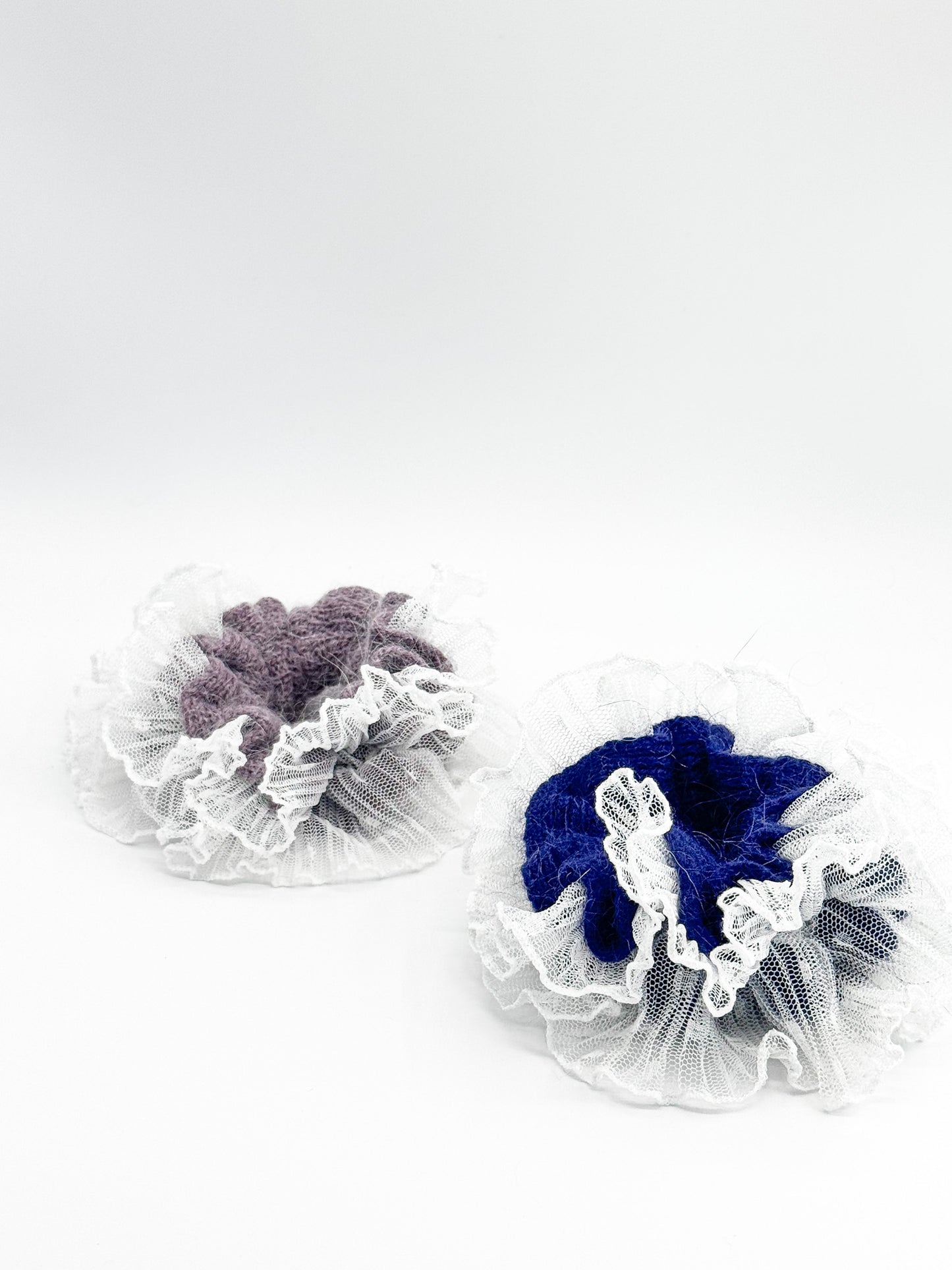 Two lace-trimmed hair scrunchies, one purple and one blue, on a white background.