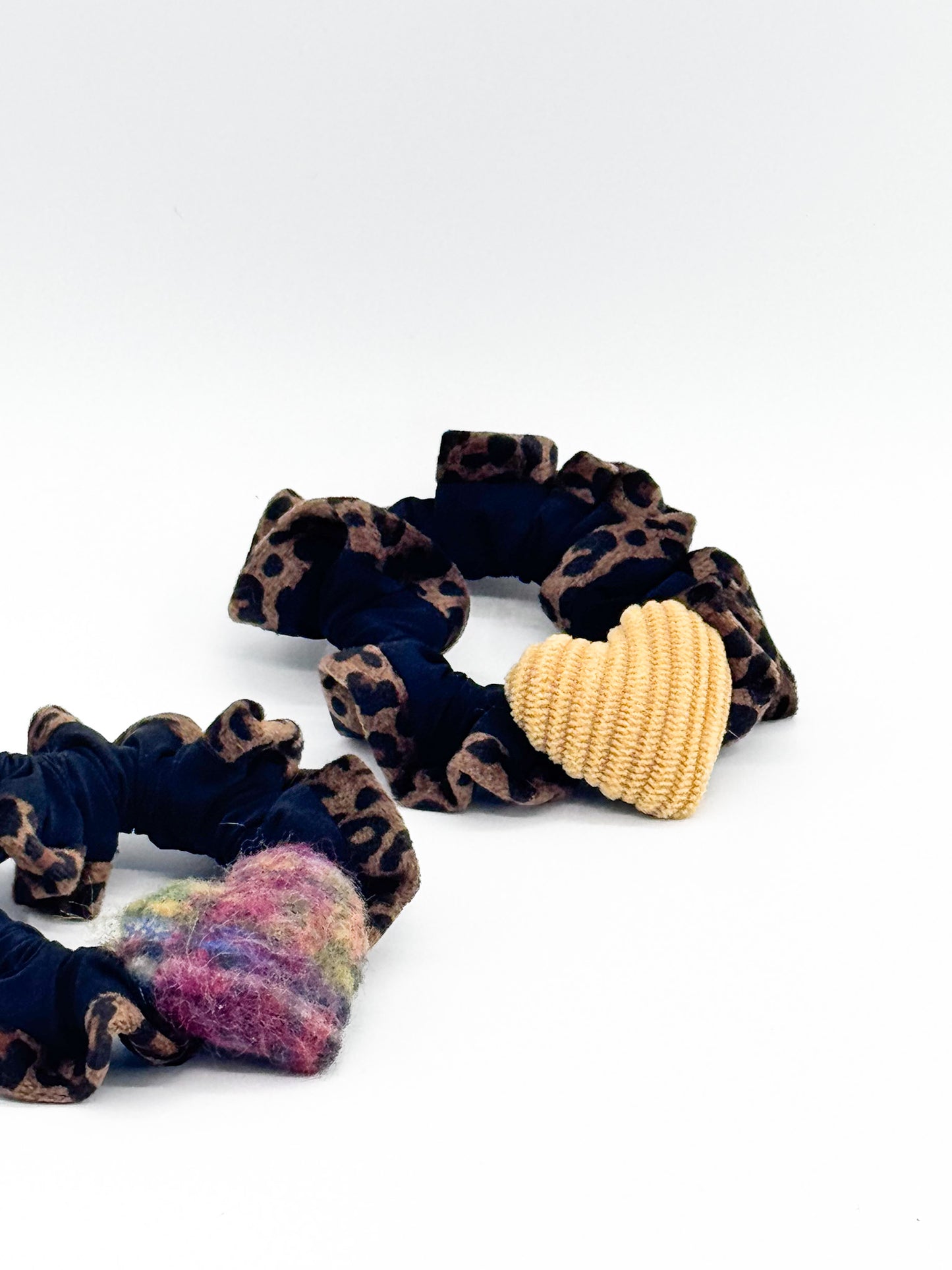 Set of colorful scrunchies with leopard print and solid colors on a white background