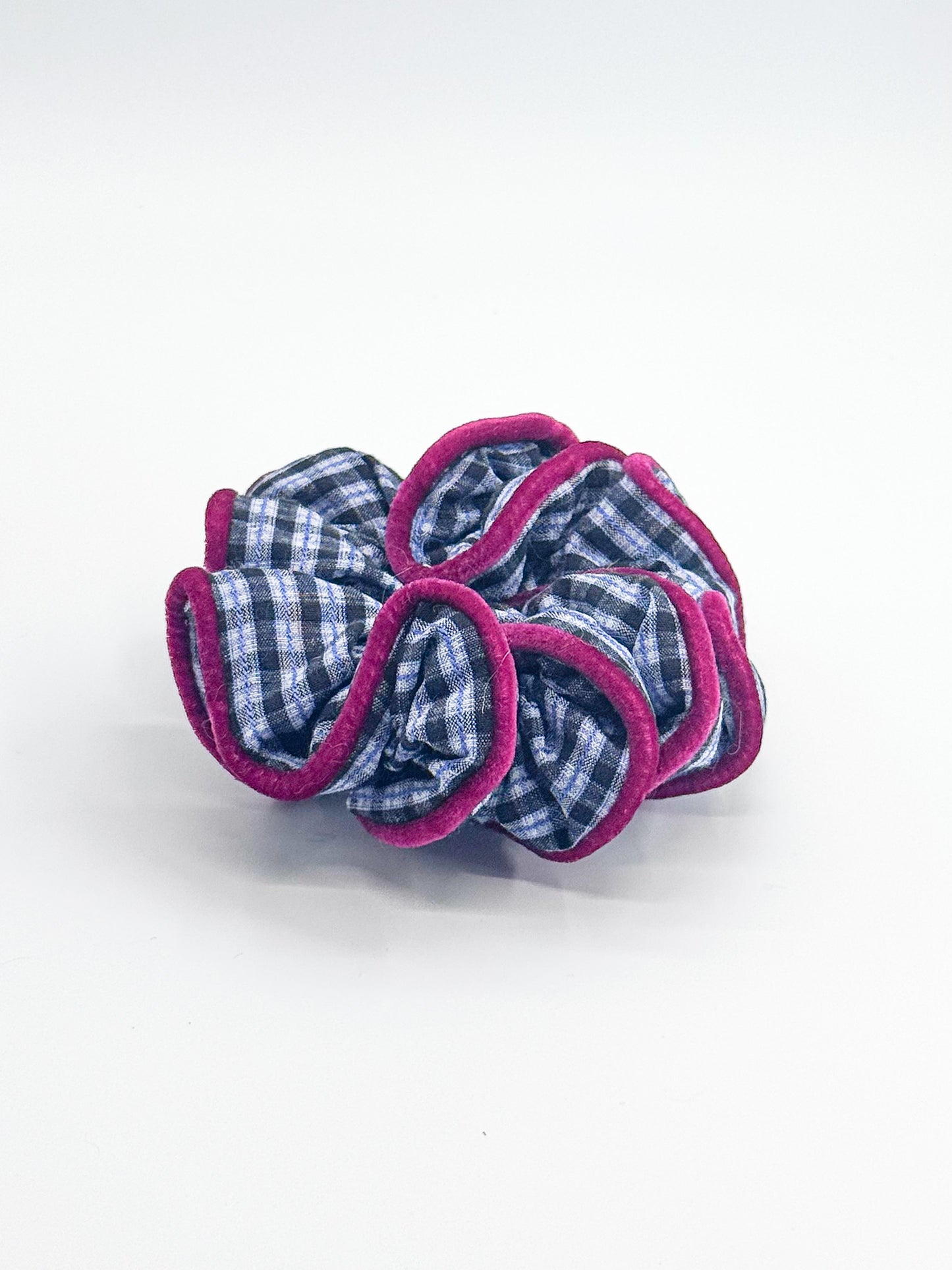 A scrunchie with blue checkered center and pink outer layers on a white background