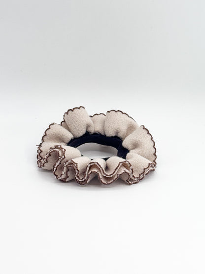 Beige scrunchie with ruffled edge on a white background