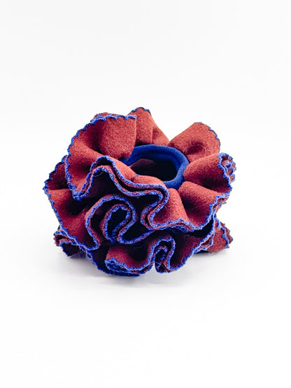 Red and blue textured flower-like scrunchies on a white background