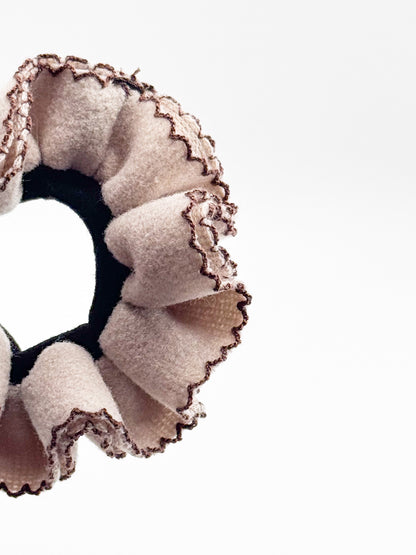Close-up of a scrunchie with ruffled edges on a white background