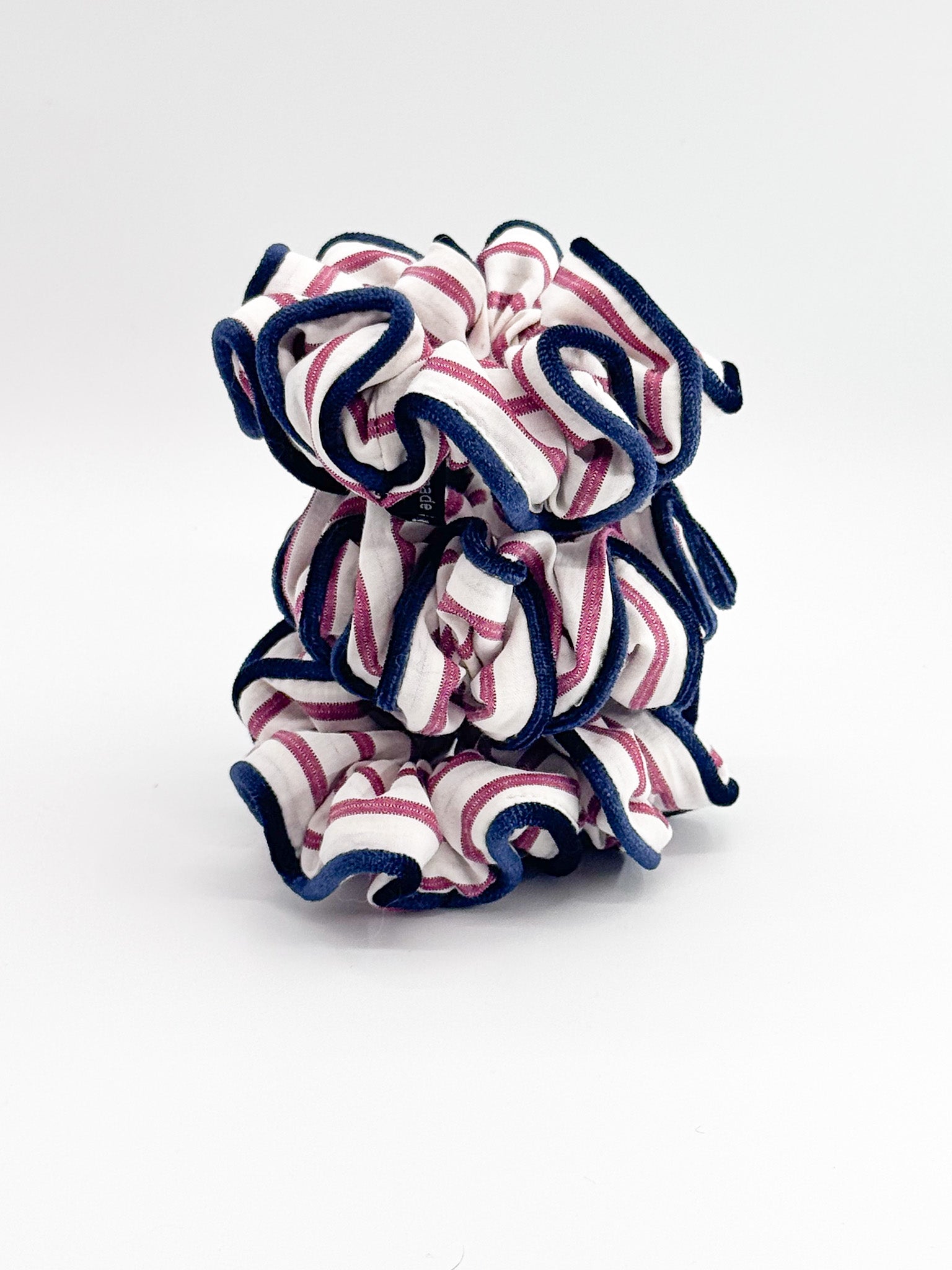 Three scrunchies with red, white, and blue pattern on a white background