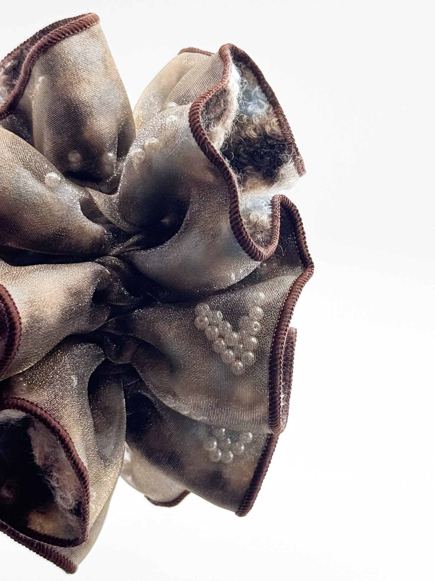 Close-up of a scrunchie with pearls on a white background