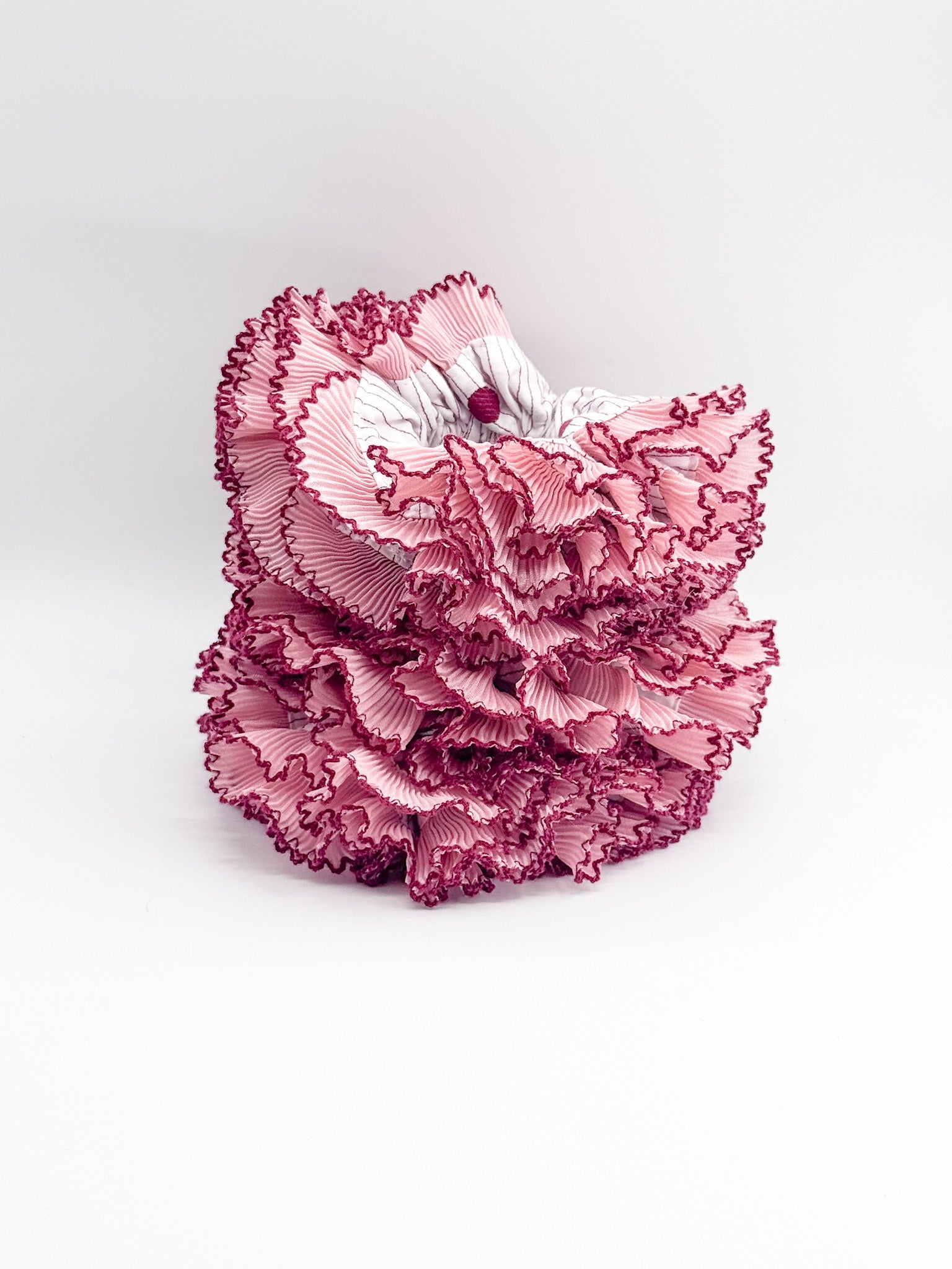 Pink lace scrunchies on a white background