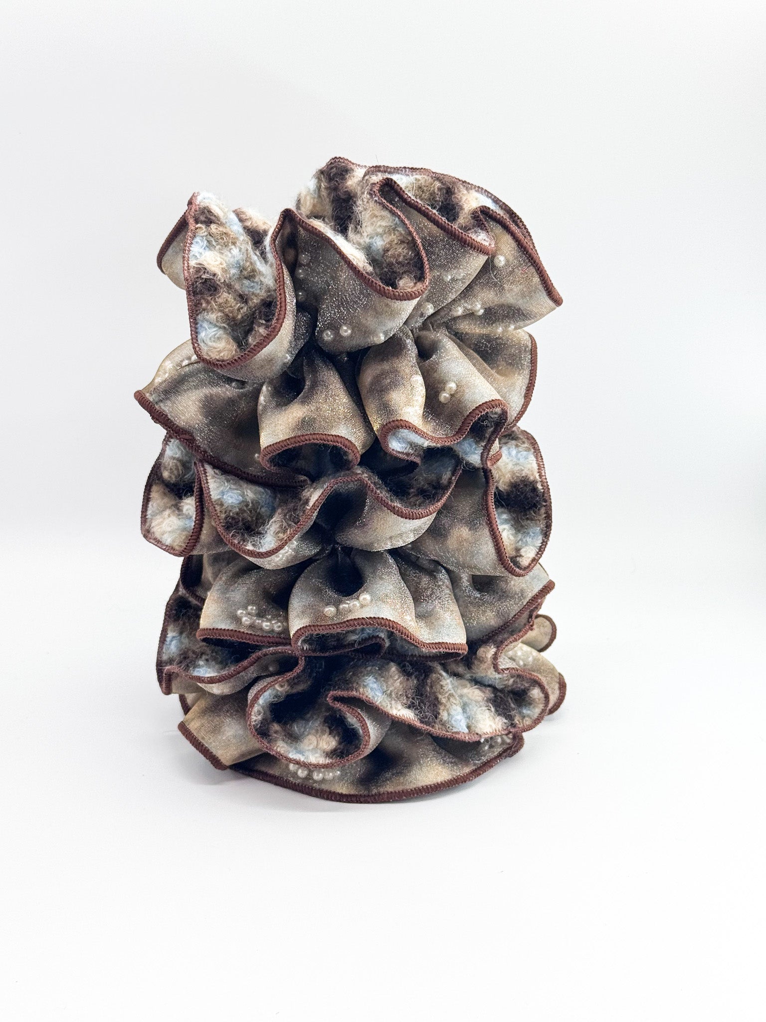 A set of brown large scrunchies with layered, ruffled design on a white background