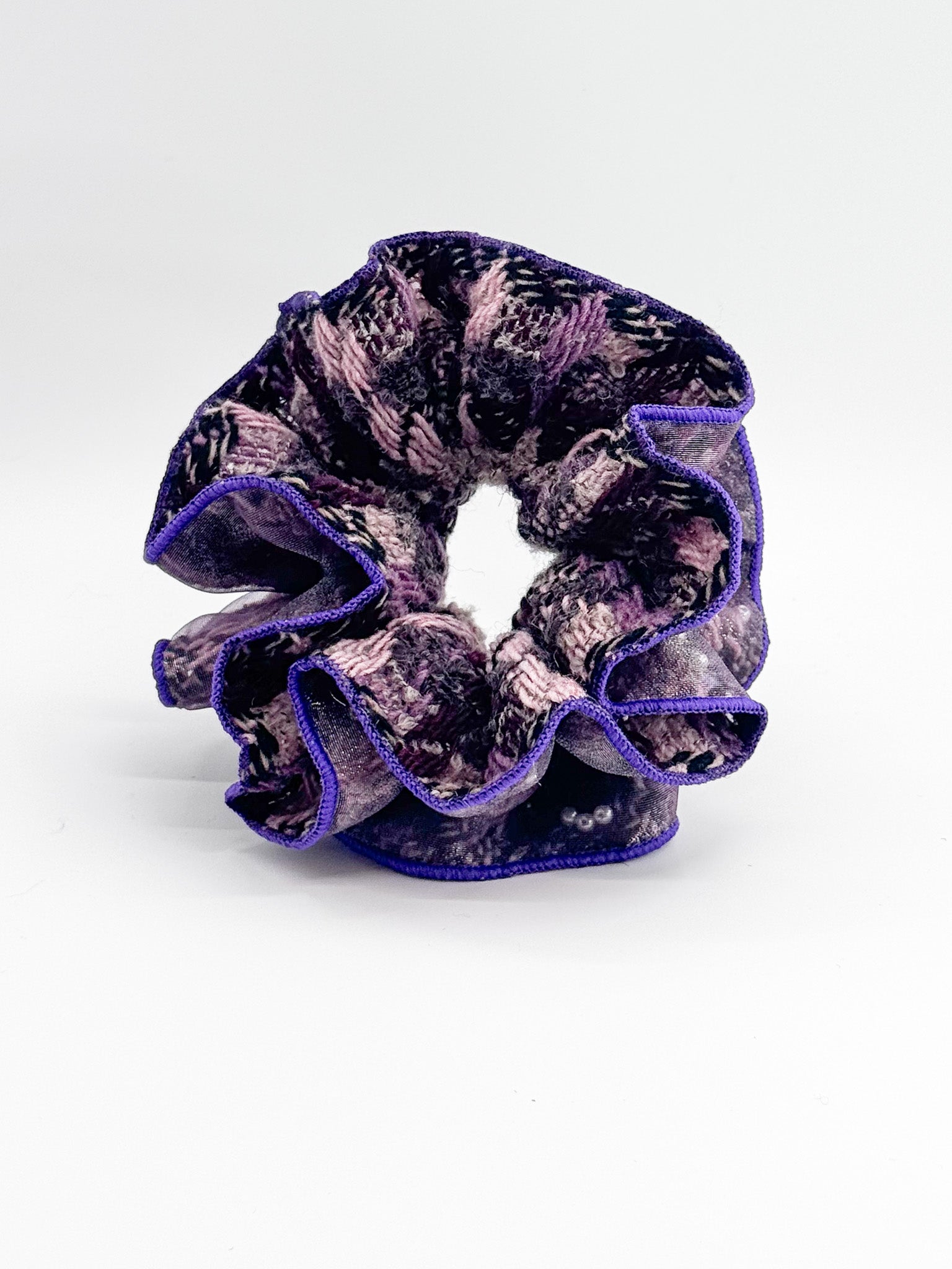 Purple and black patterned scrunchie on a white background