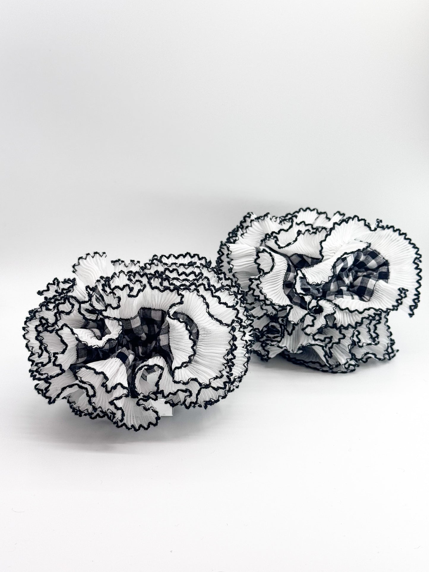 Pair of black and white lace scrunchies on a white background