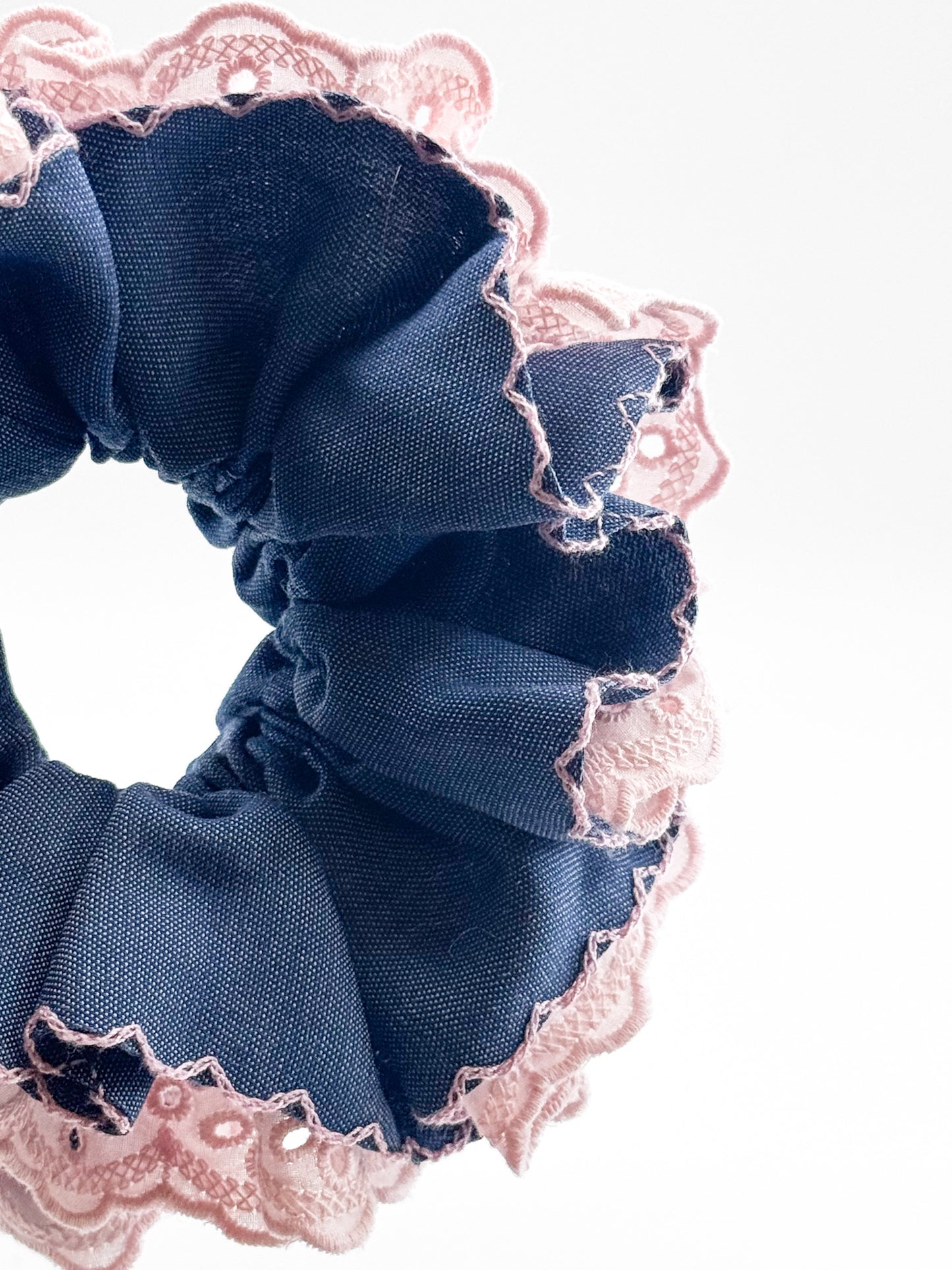 Blue scrunchie with pink lace trim on a white background