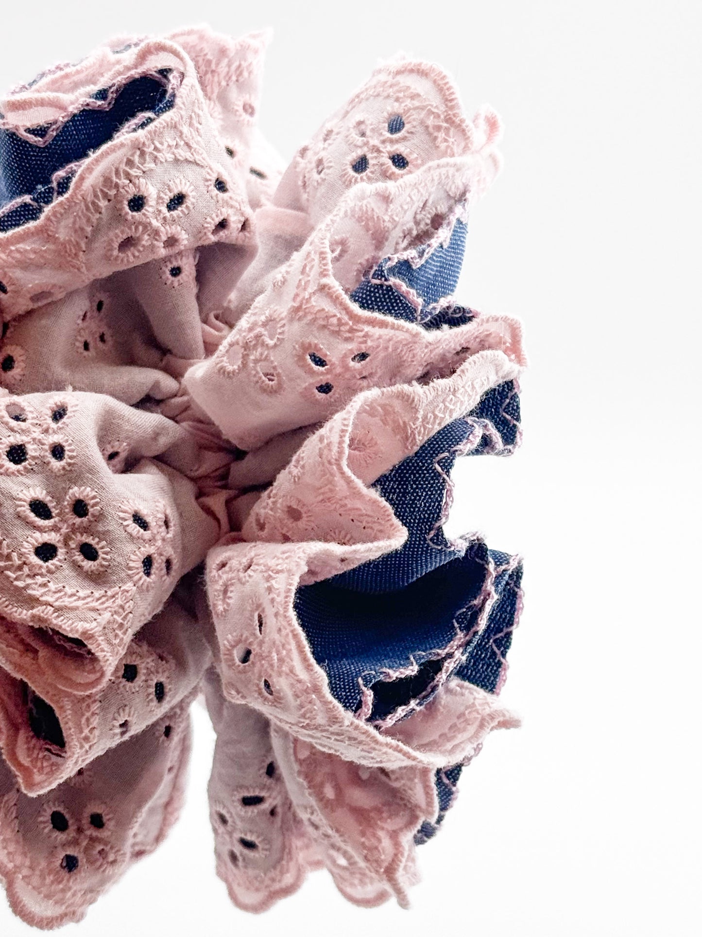 Blue denim and pink lace scrunchie on a white background