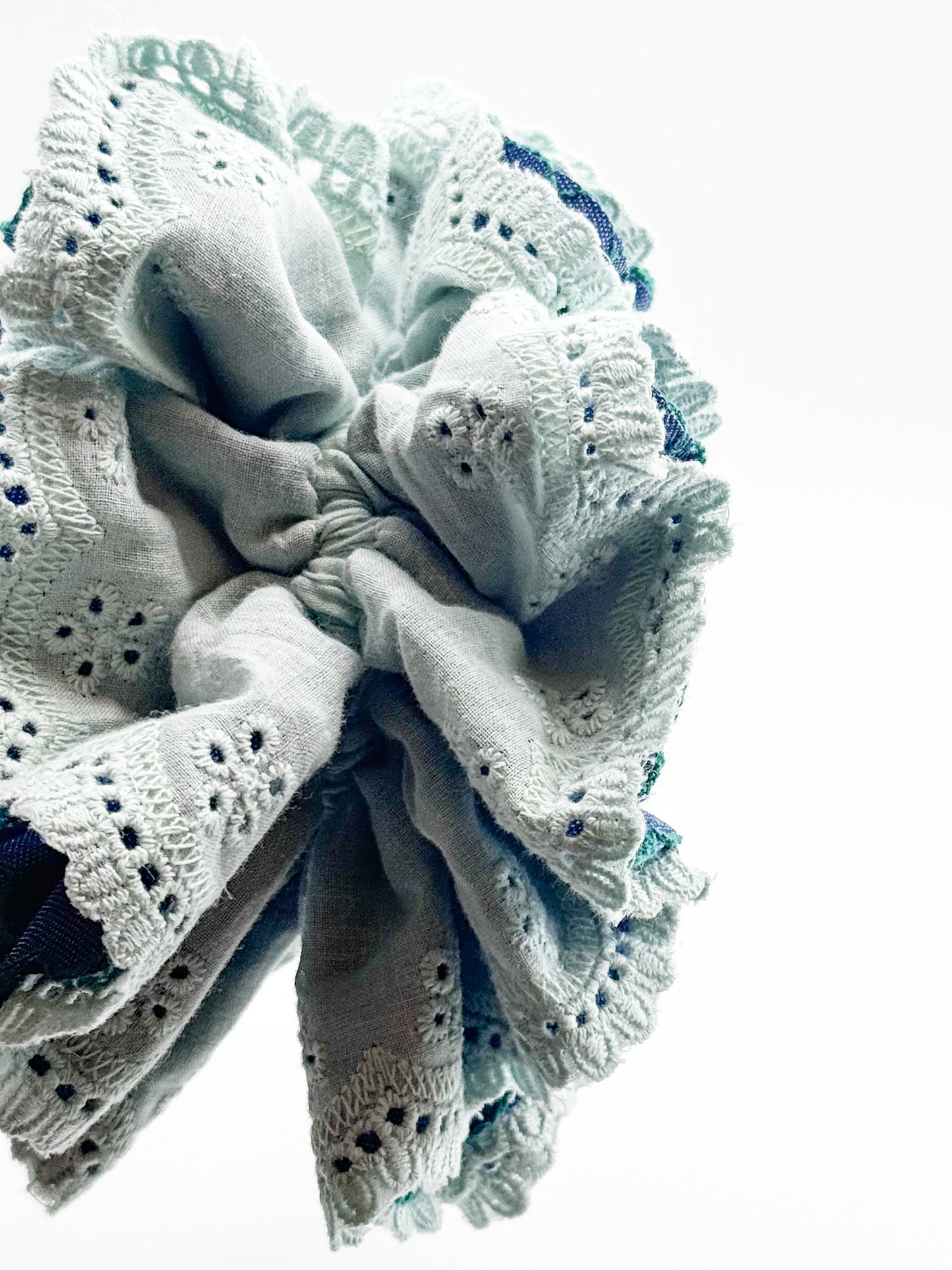 Close-up of a mint lace scrunchie on a white background