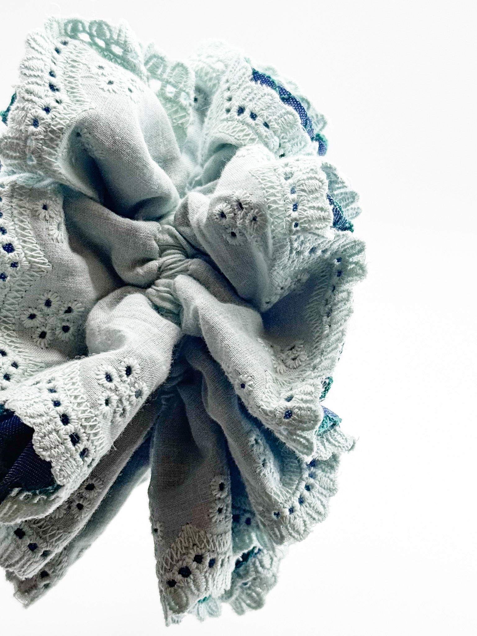 Close-up of a mint lace scrunchie on a white background